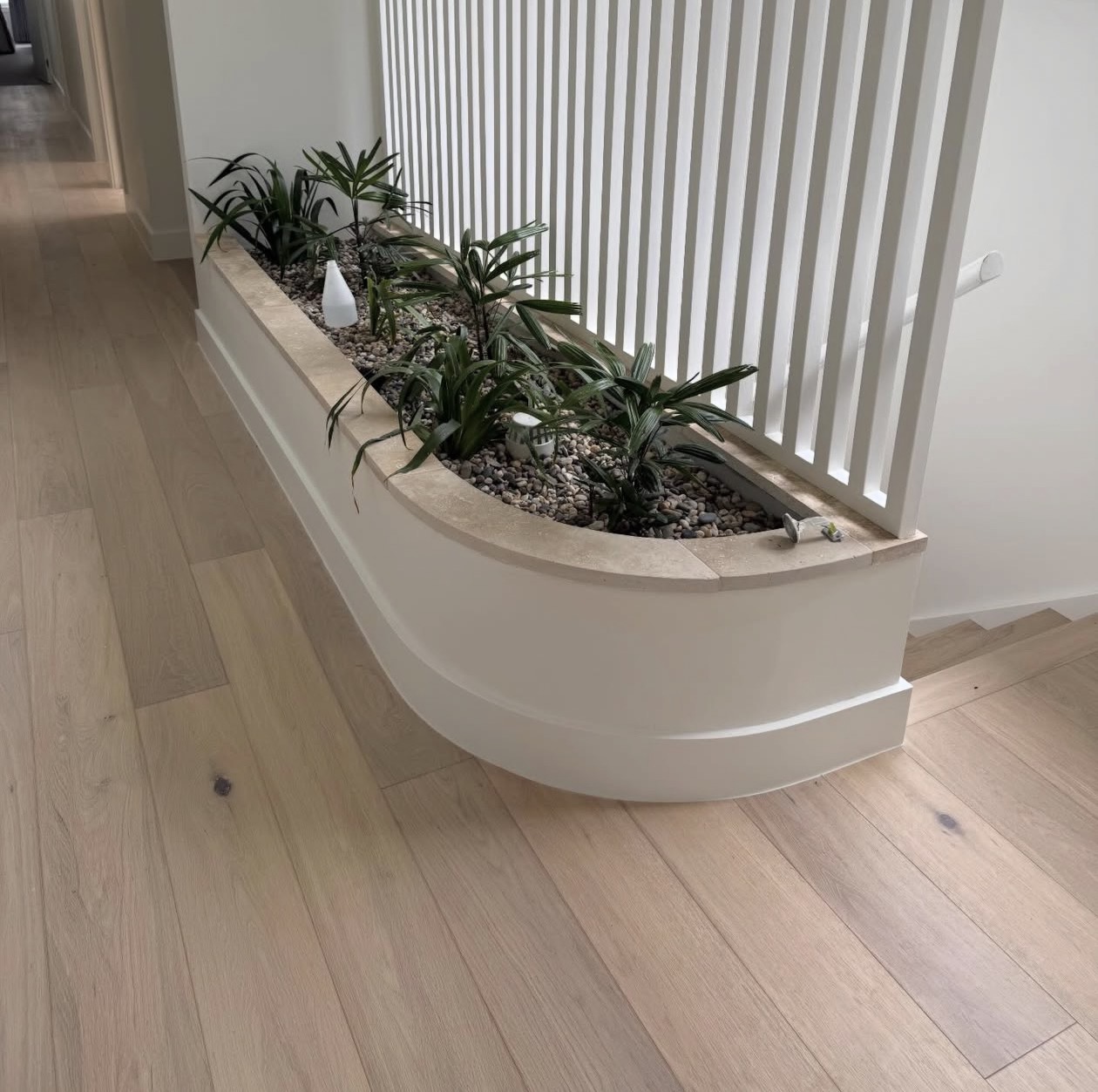 Close-up of a real NPV FLOORS plank installation fitted around a curved planter in Coachella