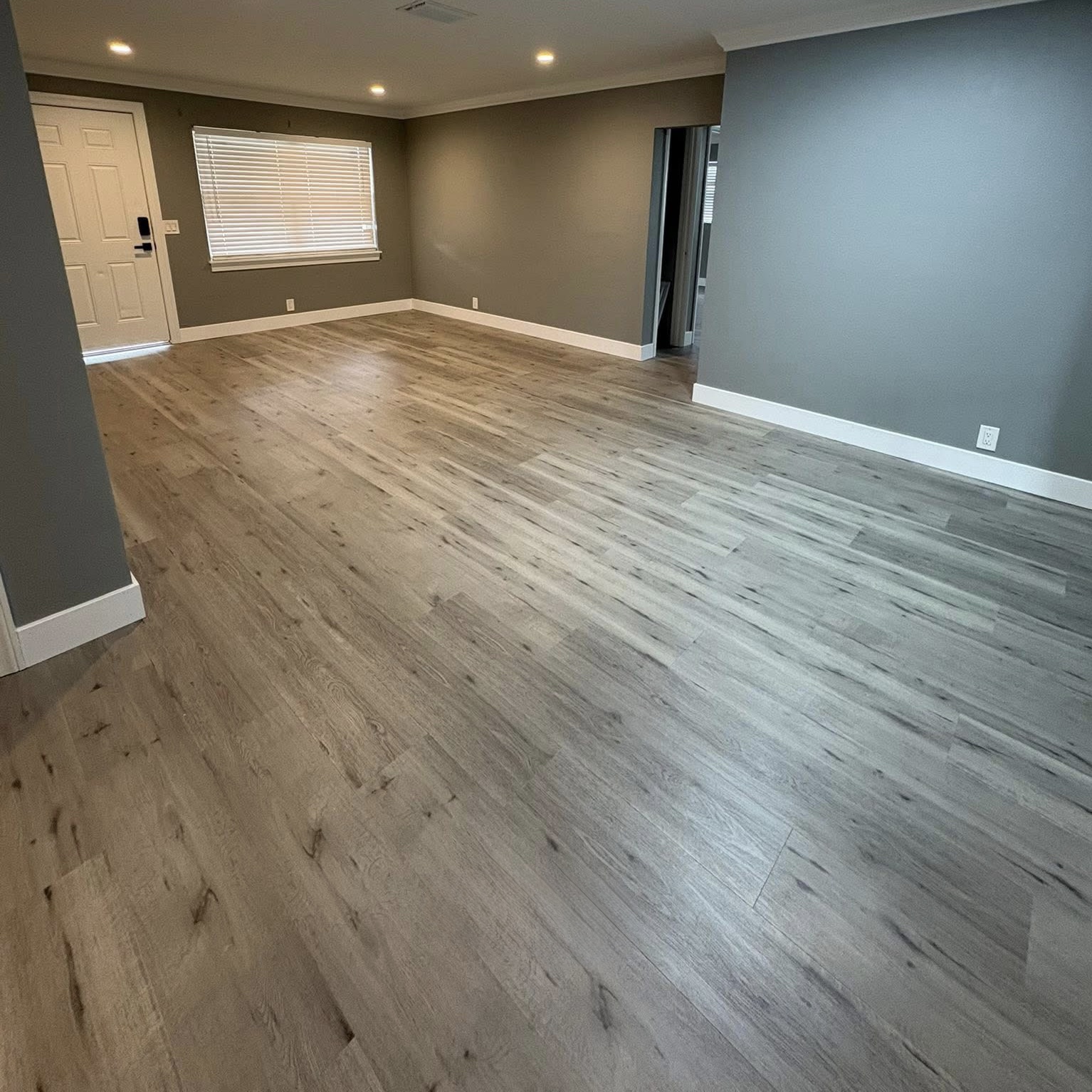 Real NPV FLOORS weathered gray oak plank flooring installed across an open living area in Indio